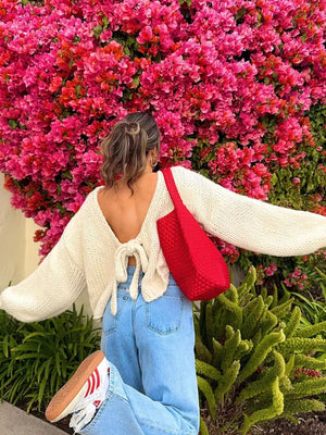 Cream textured tie-front knit cardigan with a deep V-back and tie detail.