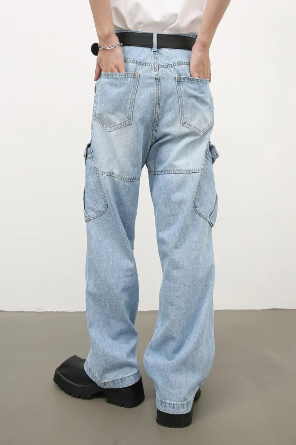 Baggy light wash denim cargo pants with utility pockets and a relaxed fit.