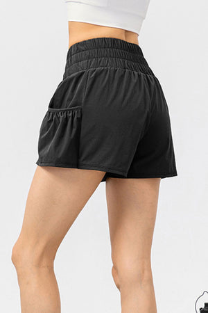 Black active shorts with gathered waistline and ruffled pocket detail.