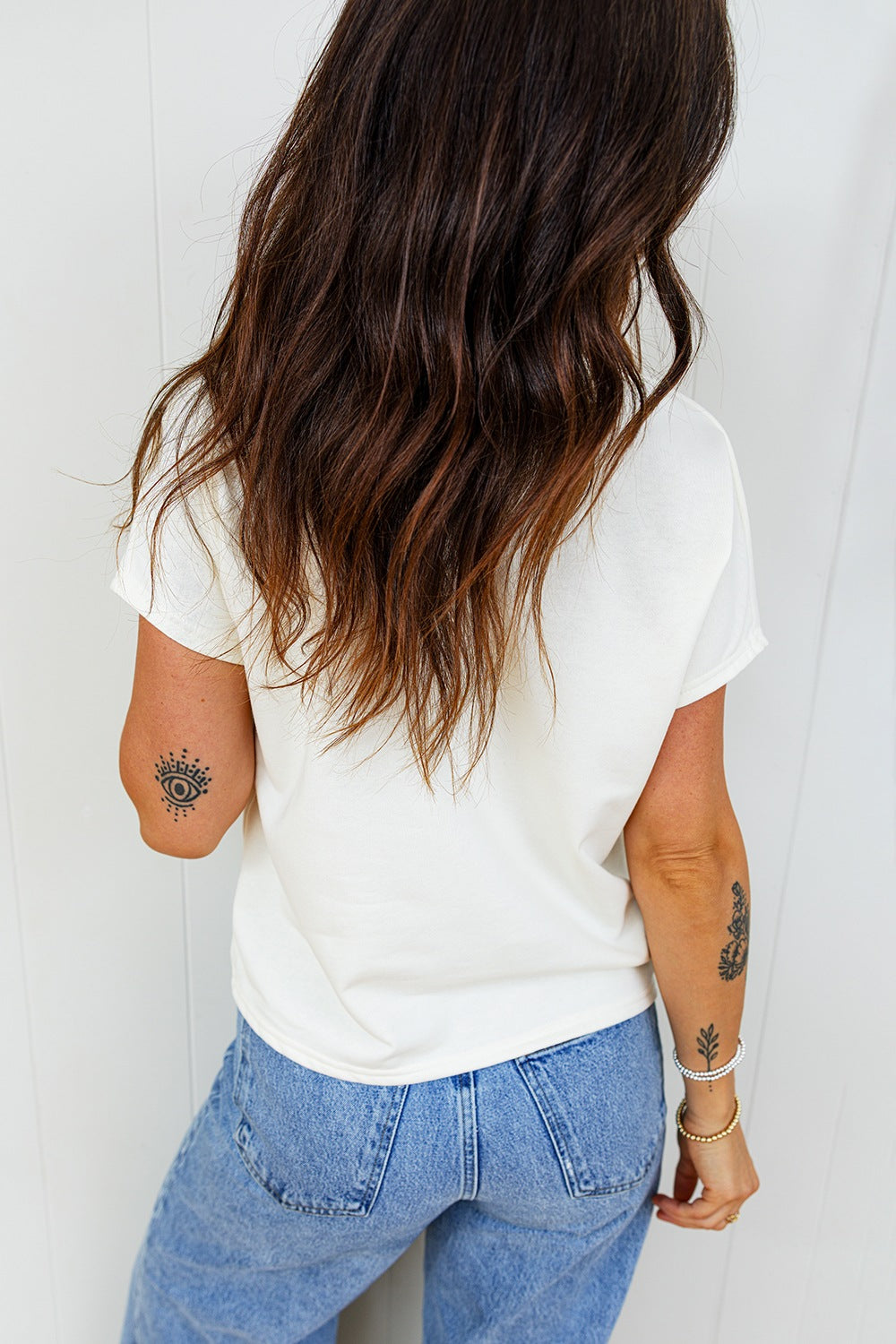 White cotton crew neck t-shirt with short sleeves, featuring a graphic print on the left sleeve.
