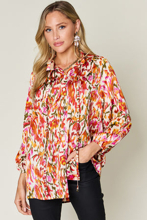 Silk ikat tie-neck blouse with abstract print in tangerine, pink, and green.