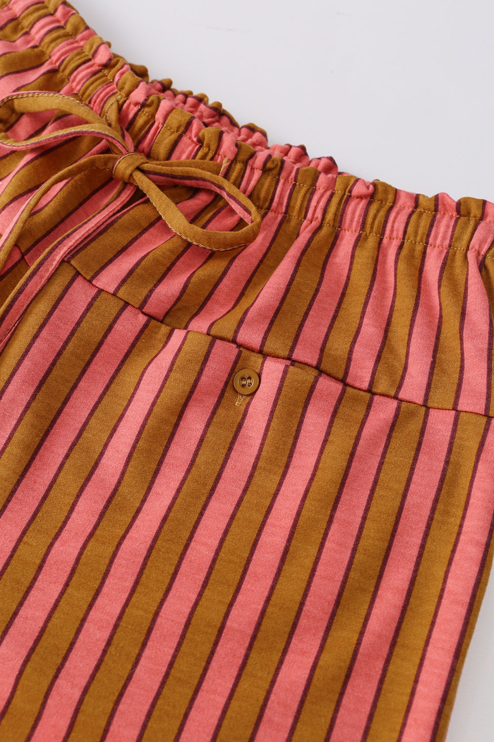 Wide leg pants with pink and brown stripes, drawstring waist, and button pocket detail.