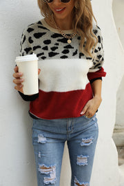 Leopard patchwork knit sweater with balloon sleeves, colorblocked in cream, red, and black.