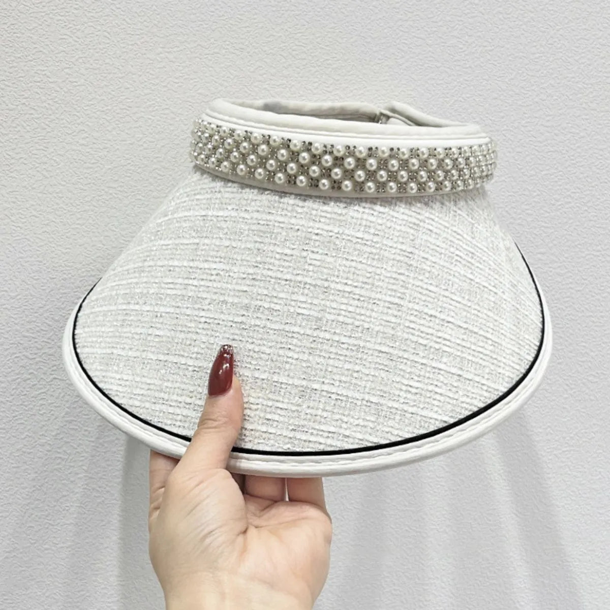 White tweed visor with pearl embellishments and black trim