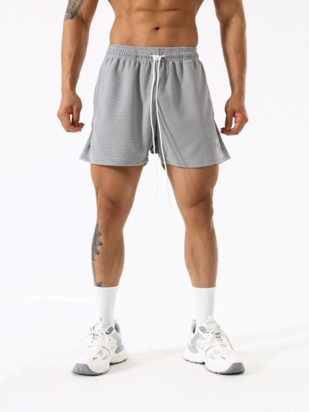Gray athletic drawstring lounge shorts with white tie and textured fabric.