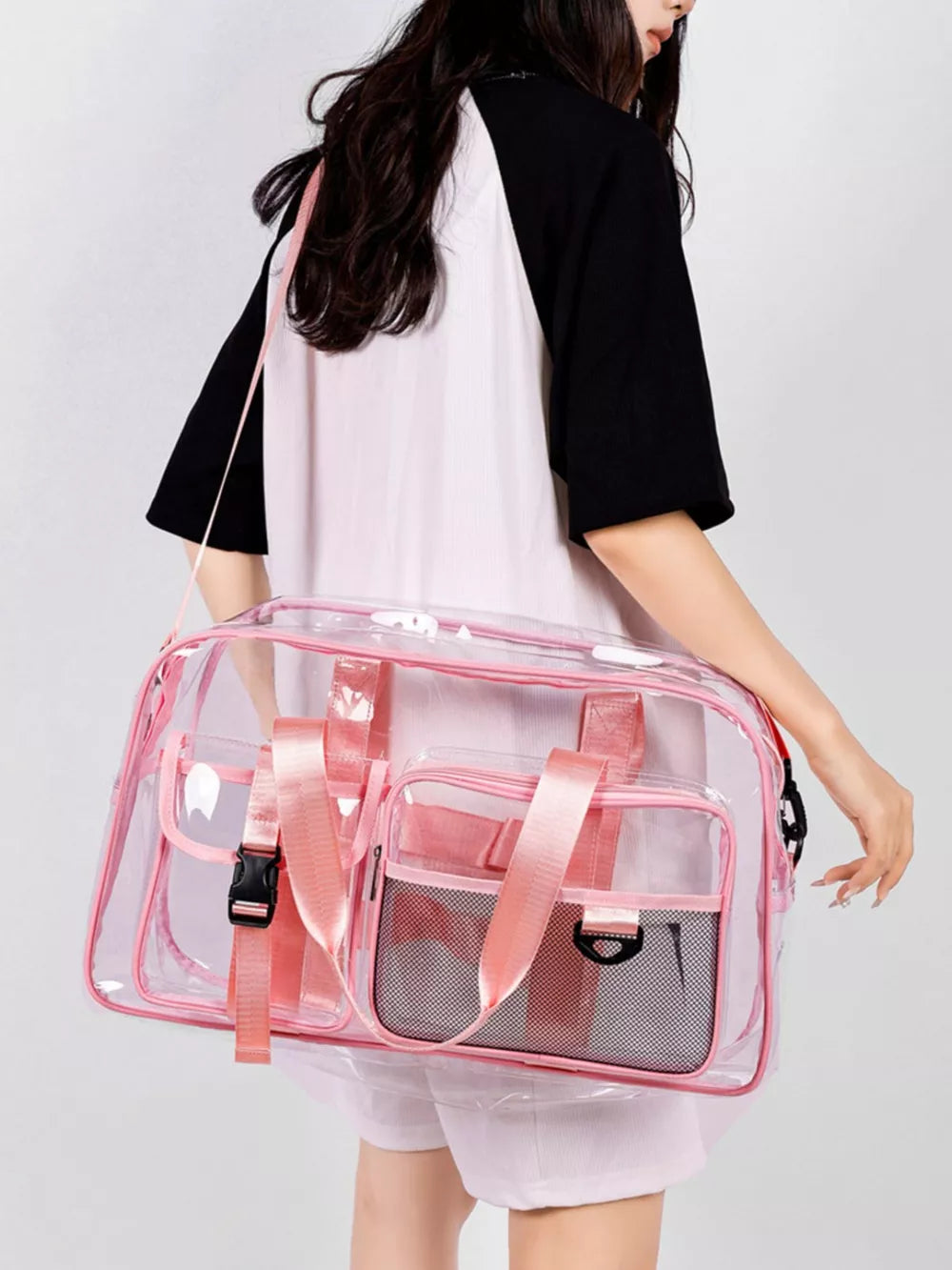Pink transparent travel duffel bag with mesh pockets and pink straps.