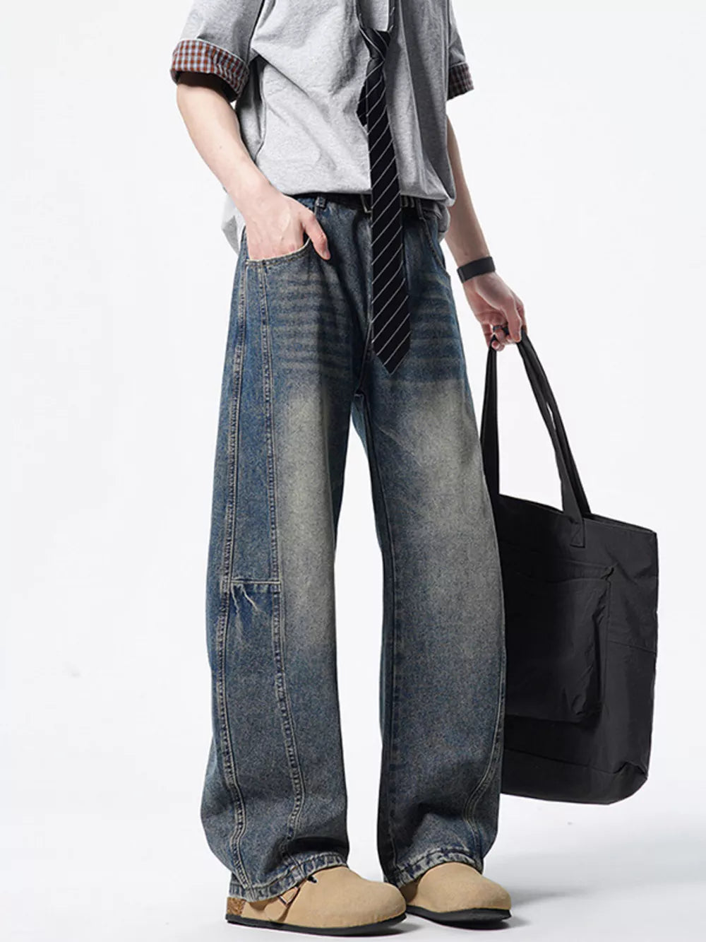 Men's light wash wide-leg denim jeans with distressed details and a vintage look.