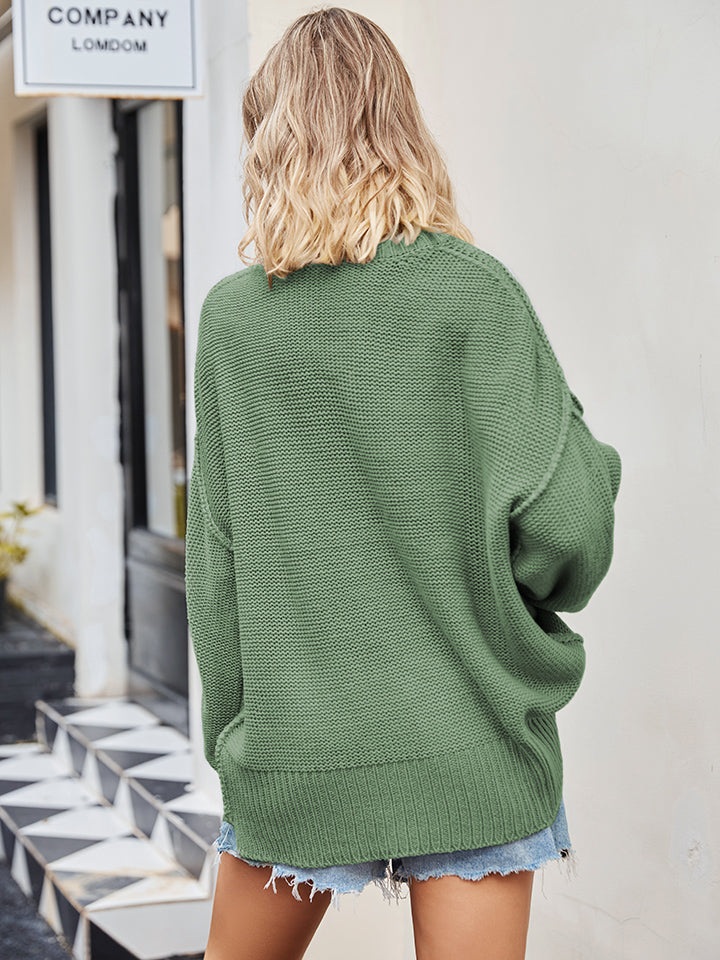 Oversized green knit V-neck sweater with slouchy fit and ribbed hem.