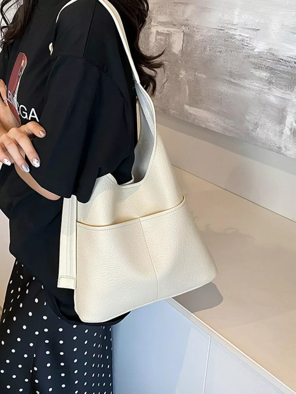 Creamy-white textured pu leather shoulder bag with adjustable strap and front pocket.