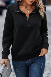 Black diamond quilted zip-neck pullover sweatshirt with long sleeves.