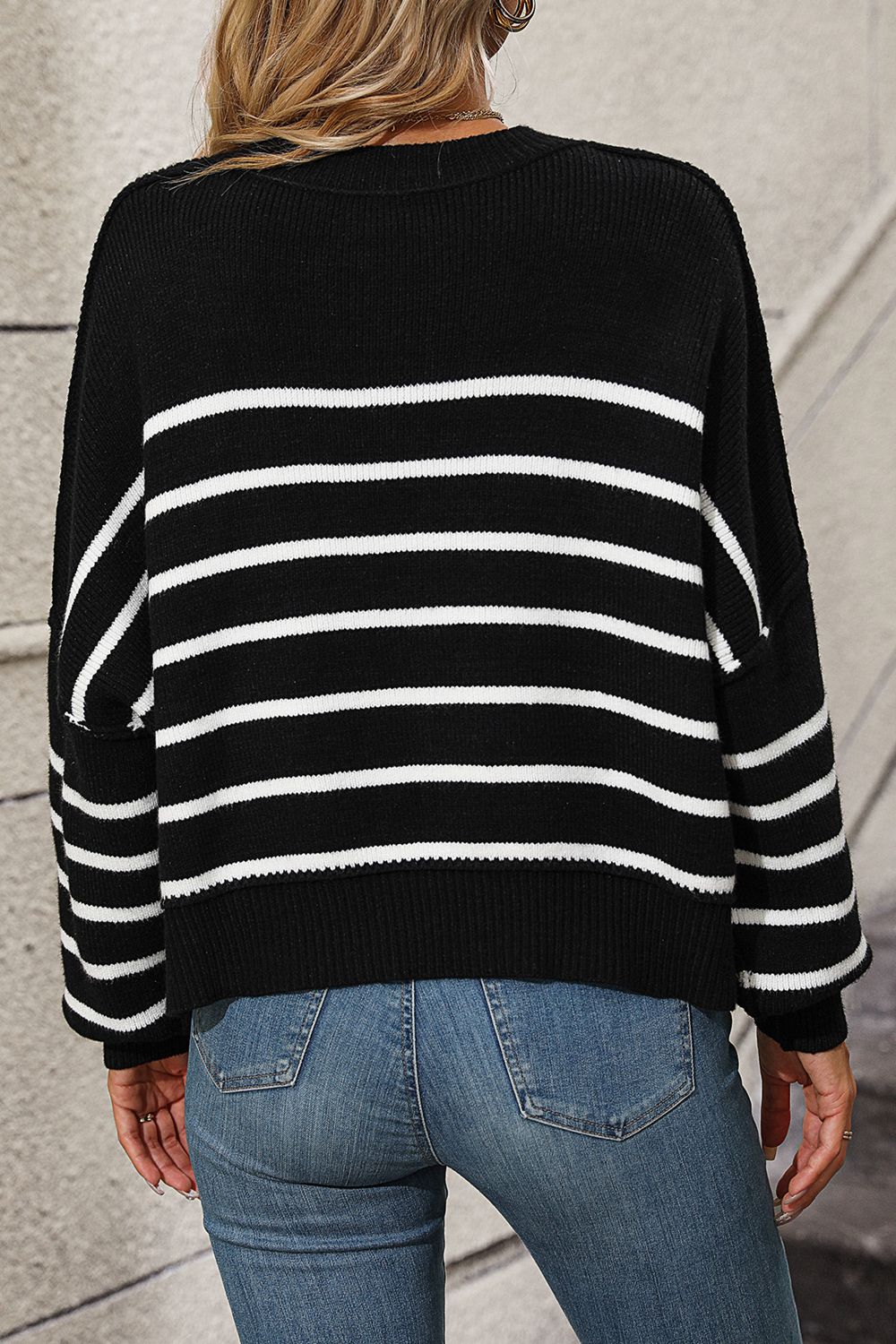 Black and white striped boxy knit sweater with crew neck and long sleeves.