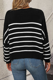 Black and white striped boxy knit sweater with crew neck and long sleeves.