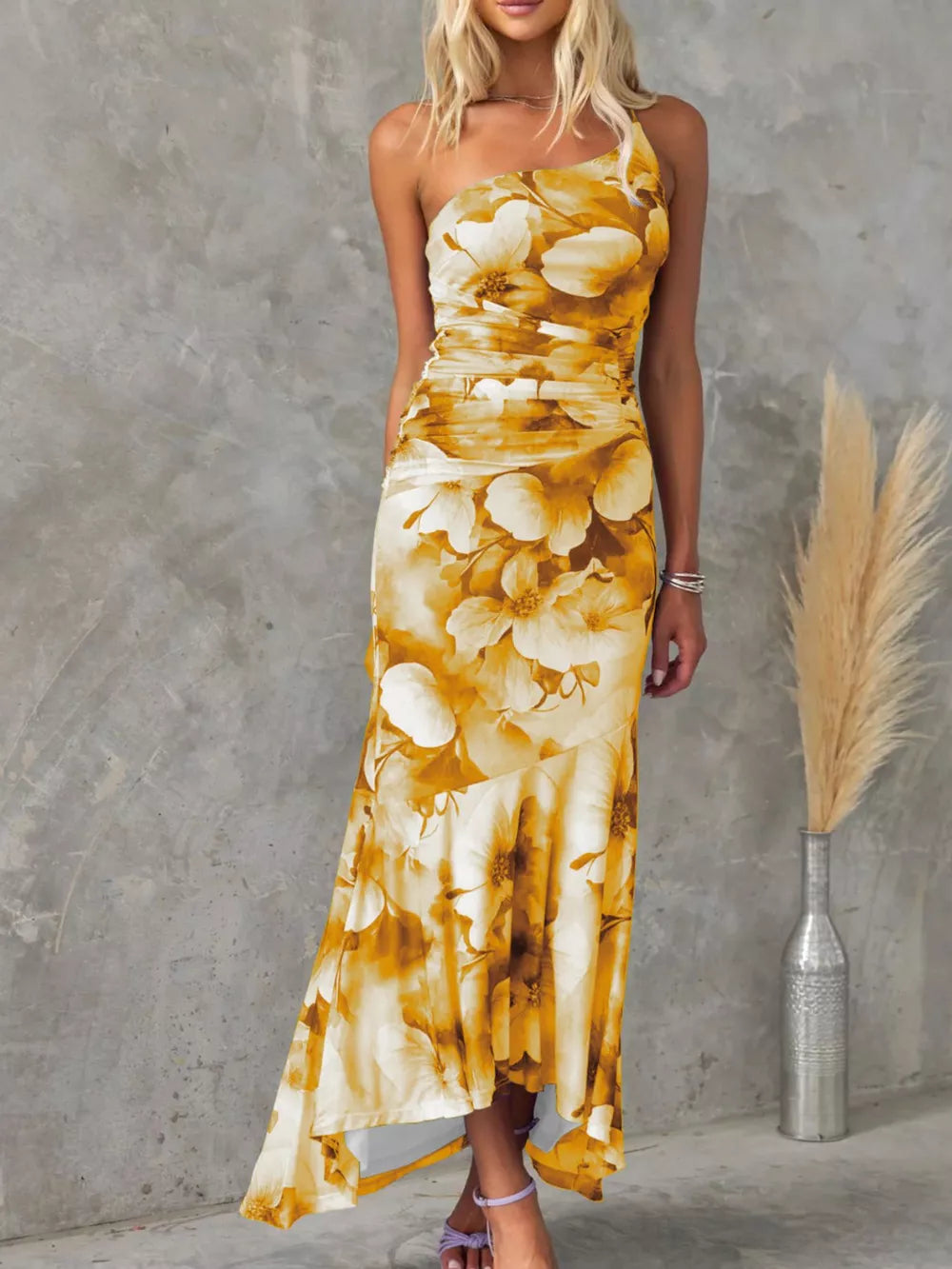 Yellow floral one-shoulder maxi dress with ruched detail and asymmetrical hem.