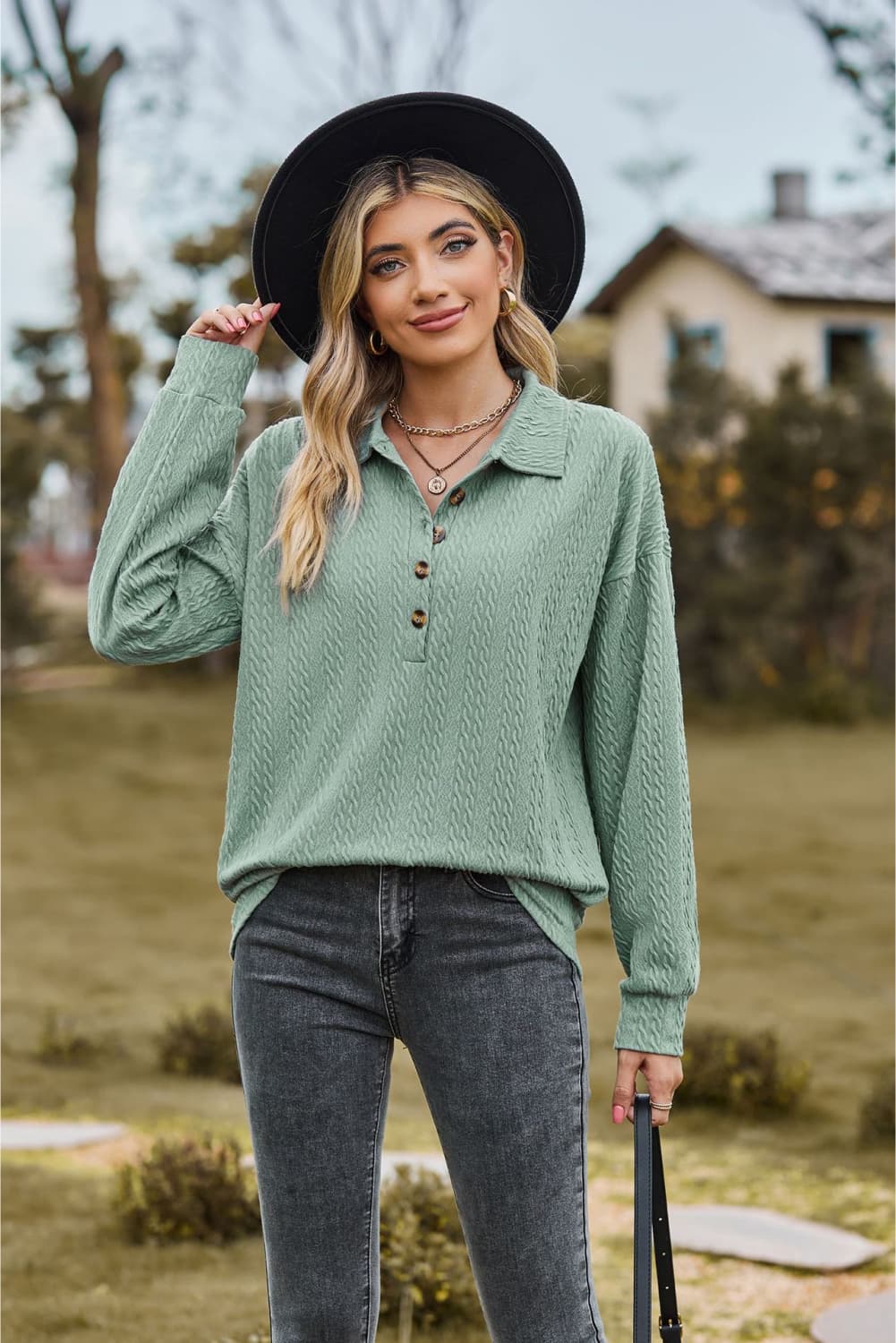Sage green textured knit polo shirt with button detail and long sleeves.