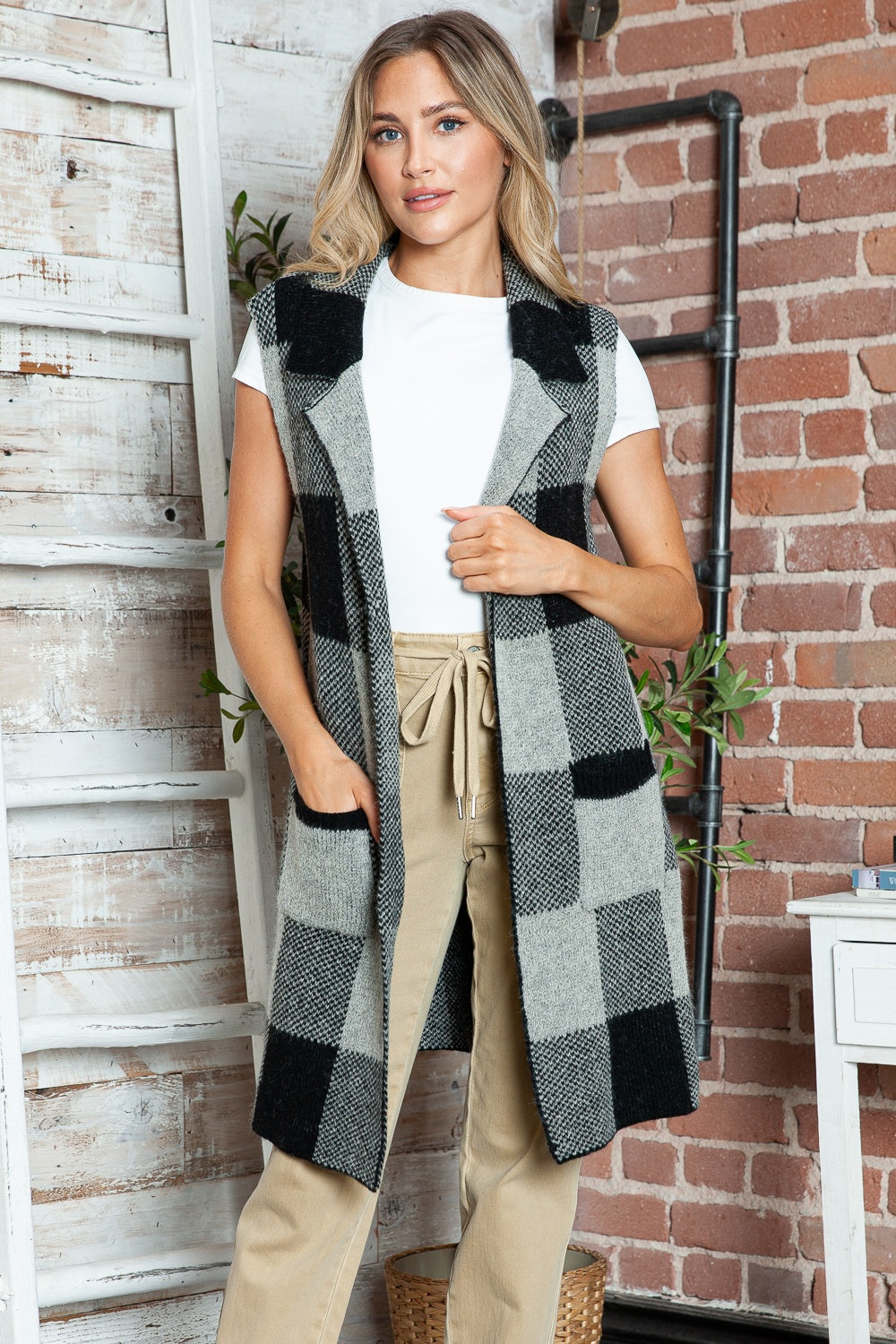 Geometric knit duster vest in black and tan checkered pattern with pockets.