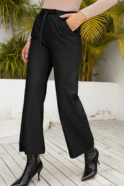 Black Luxe Drape Wide-Leg Drawstring Pants with pockets and a tie waist.