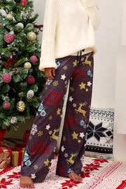 Festive print wide-leg lounge trousers in dusty purple with reindeer, stars, snowflakes, and Merry Christmas text.