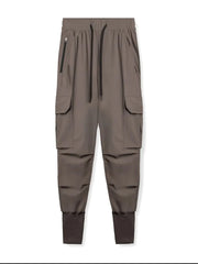 Mocha technical cargo joggers with ribbed cuffs and zippered pocket detail.