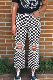 Checkerboard distressed cropped jeans with ripped knees and frayed hem.