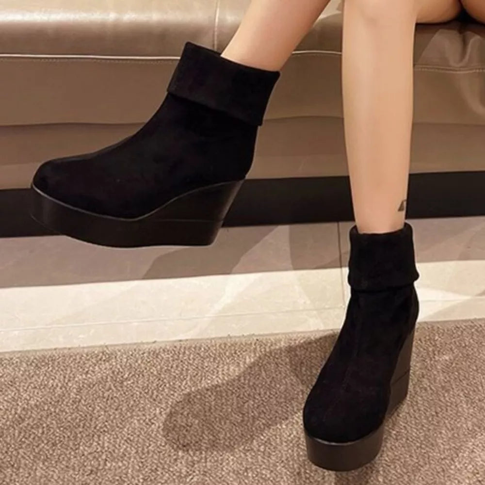 Black suede wedge boots with a platform and folded cuff detail.
