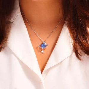 Silver celestial necklace with a blue cosmic orb, crescent moon, and star charm.