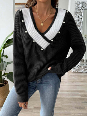 Black ribbed knit sweater with pearl trim V-neck and white stripe detail.