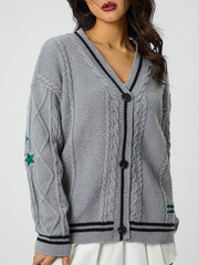 Gray cable knit cardigan with black stripe V-neck and green stars on sleeve.