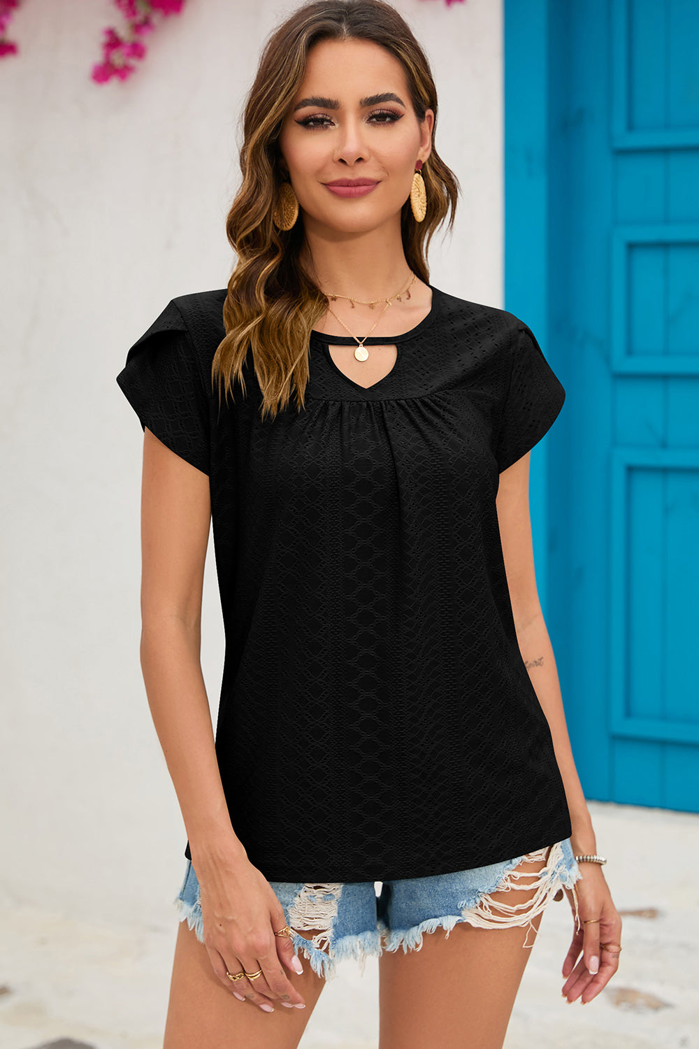 Black eyelet cap-sleeve top with keyhole neckline and ruffled sleeves.