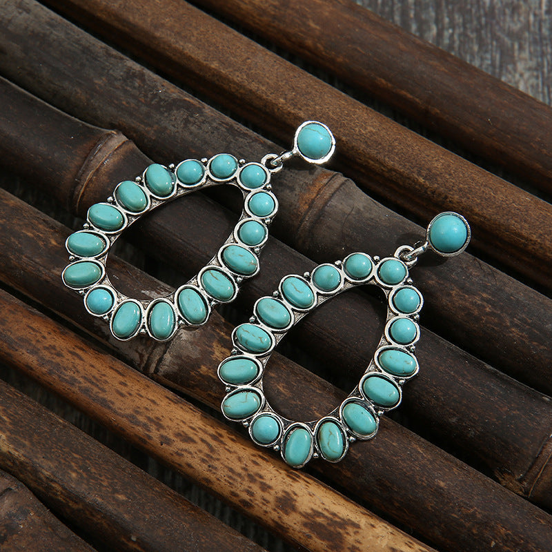 Teal teardrop statement earrings with artificial turquoise stones and silver alloy setting.