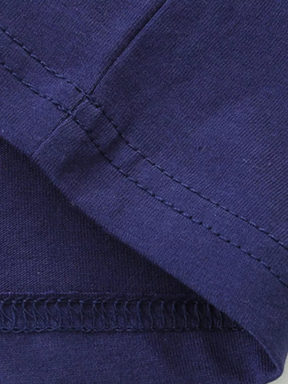 Navy blue 100% cotton t-shirt detail showing double-stitched seams and fabric texture.