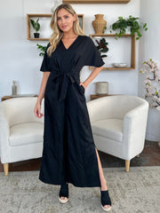 Black wrap jumpsuit with V-neck, short sleeves, belted waist, and slit legs.