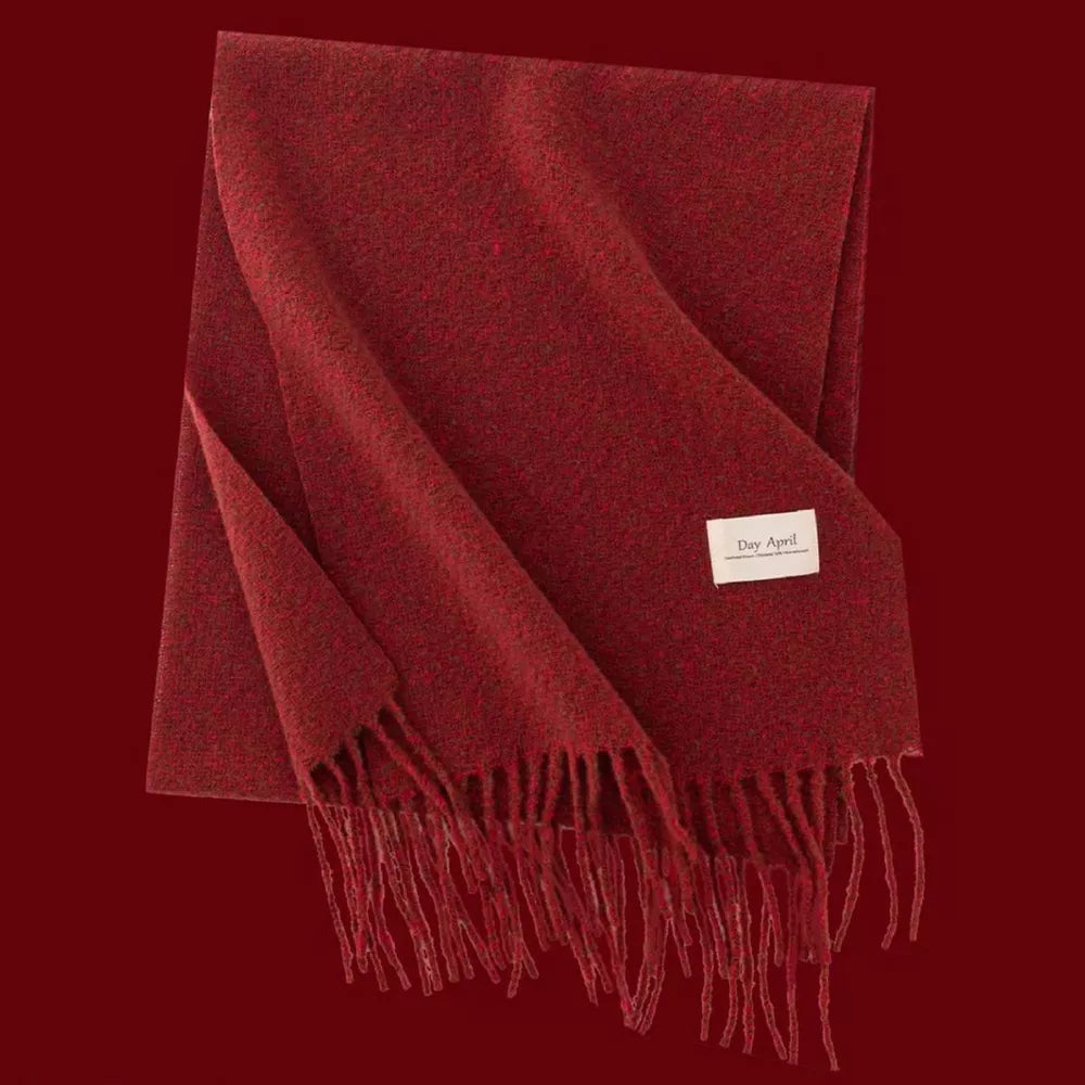 Cozy red plaid scarf with fringe detail and a small white tag.