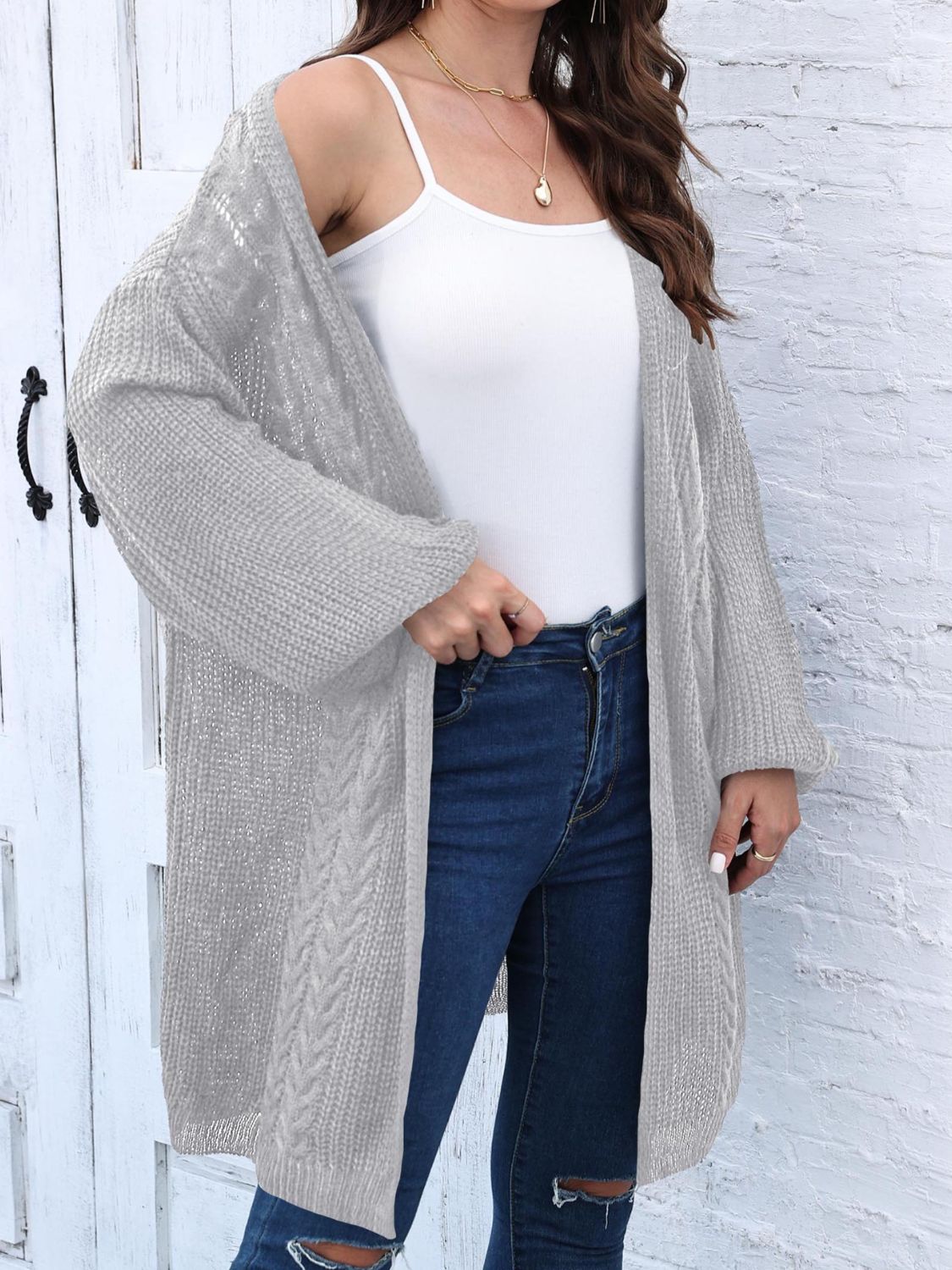 Light gray cable knit cocoon cardigan with open front and long sleeves.