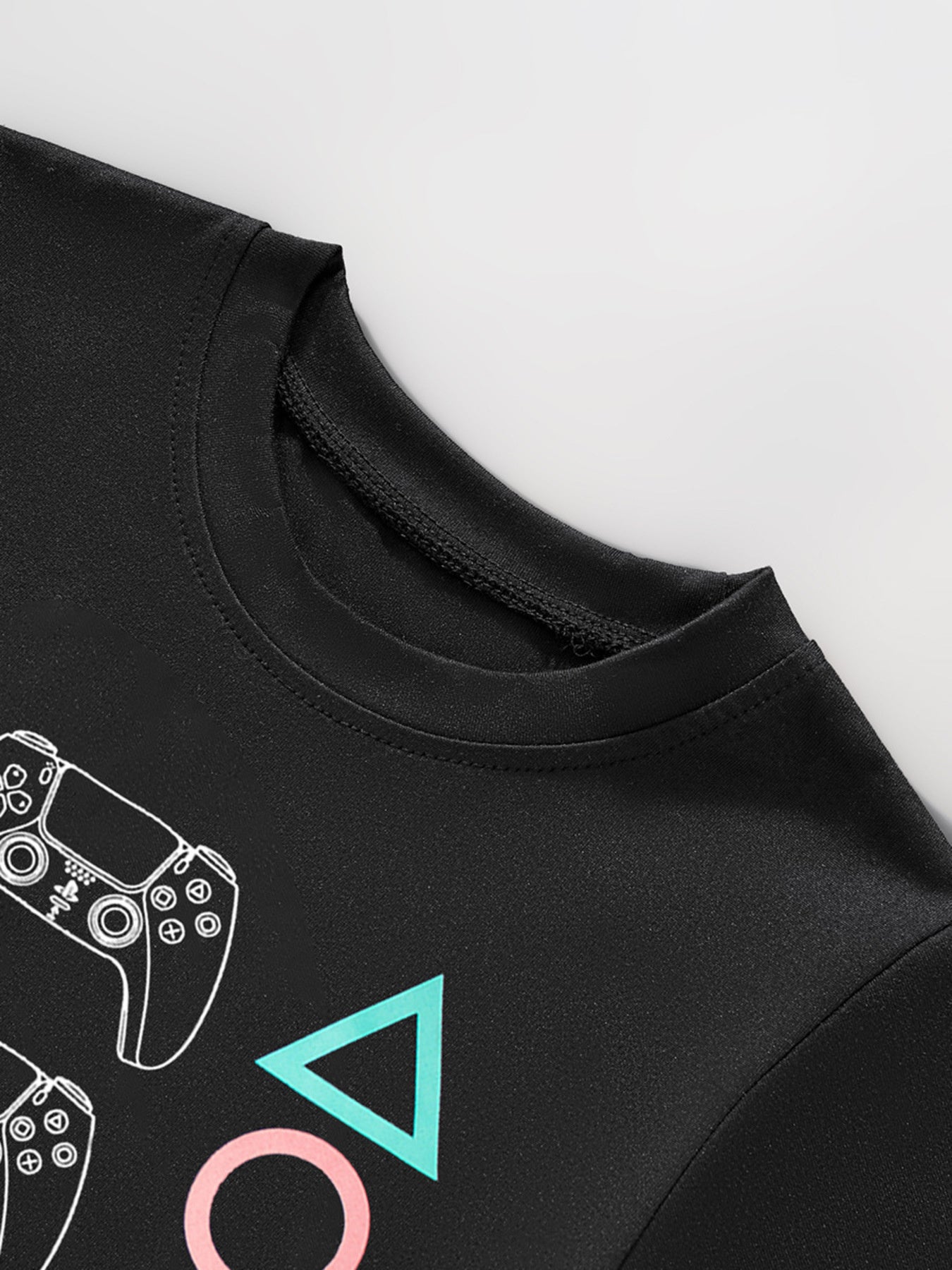 Black toddler t-shirt with white gaming controller graphic and colorful shapes.