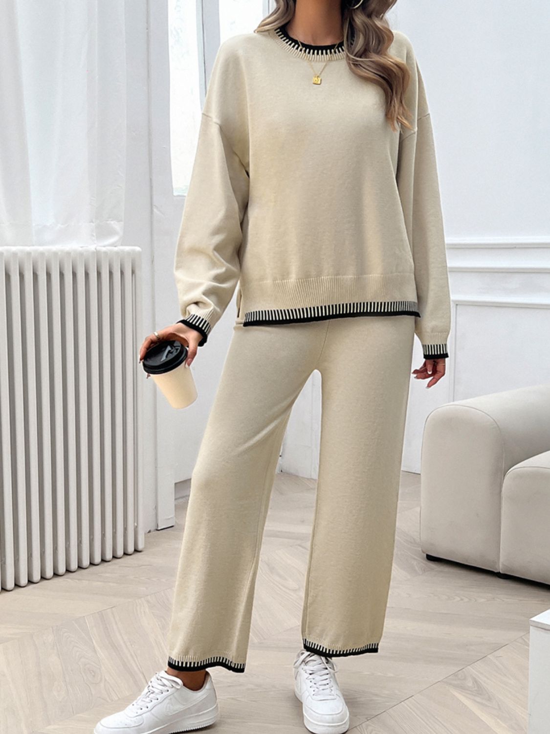 Beige knit lounge set with black ribbed trim on neckline, cuffs, and hem.