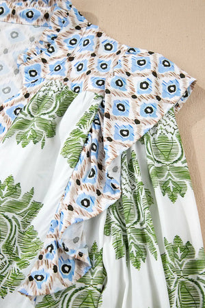 Vibrant floral patchwork ruffle mini dress with green leaf print and blue floral accents.