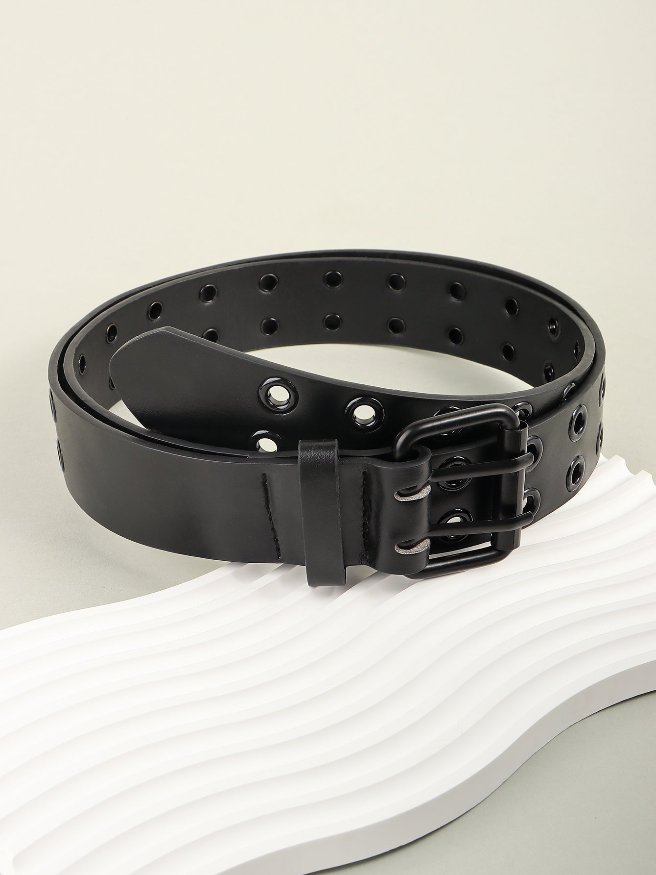 Black vegan leather belt with double row of grommets and double buckle.