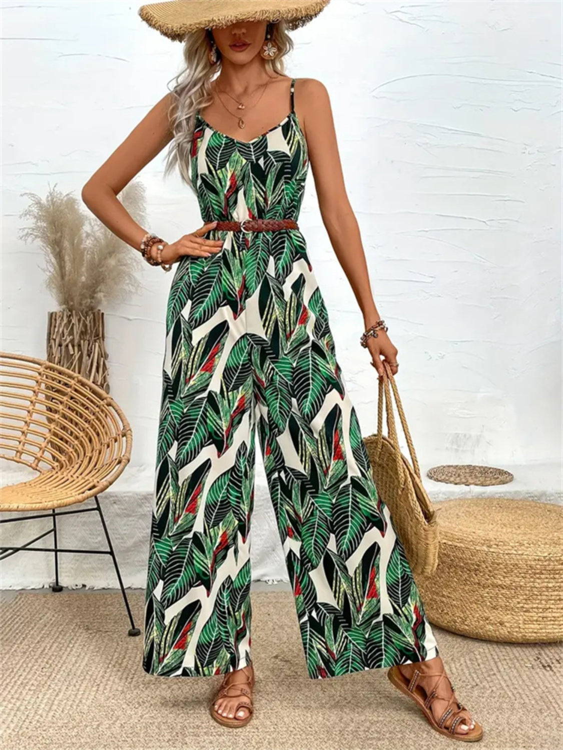 Botanical print cami jumpsuit in dark green with wide legs and a braided belt.