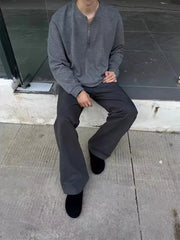 Men's dark gray sweatpants with a relaxed fit, styled with black shoes.