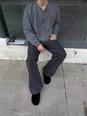 Men's dark gray sweatpants with a relaxed fit, styled with black shoes.