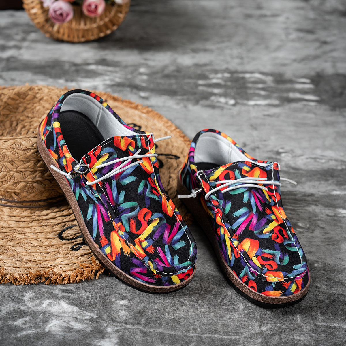 Printed casual slip-on loafers with abstract brushstroke pattern in black with multi-color accents.