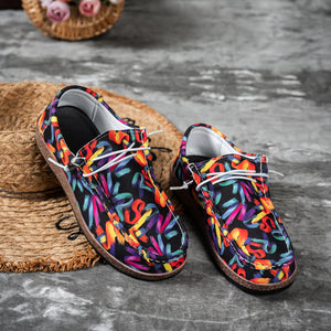 Printed casual slip-on loafers with abstract brushstroke pattern in black with multi-color accents.