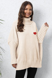 Beige knit turtleneck sweater with batwing sleeves and a red heart embroidery detail.