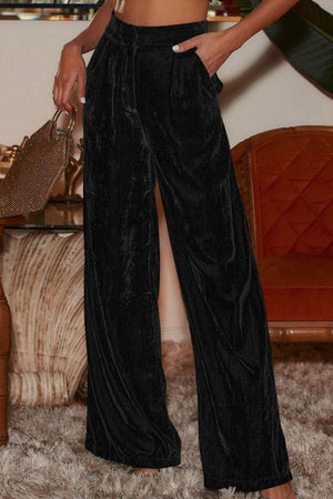 Black velvet palazzo trousers with high waist and wide legs.