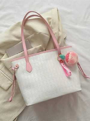 Textured diamond woven tote bag with pink trim and a fruit charm.
