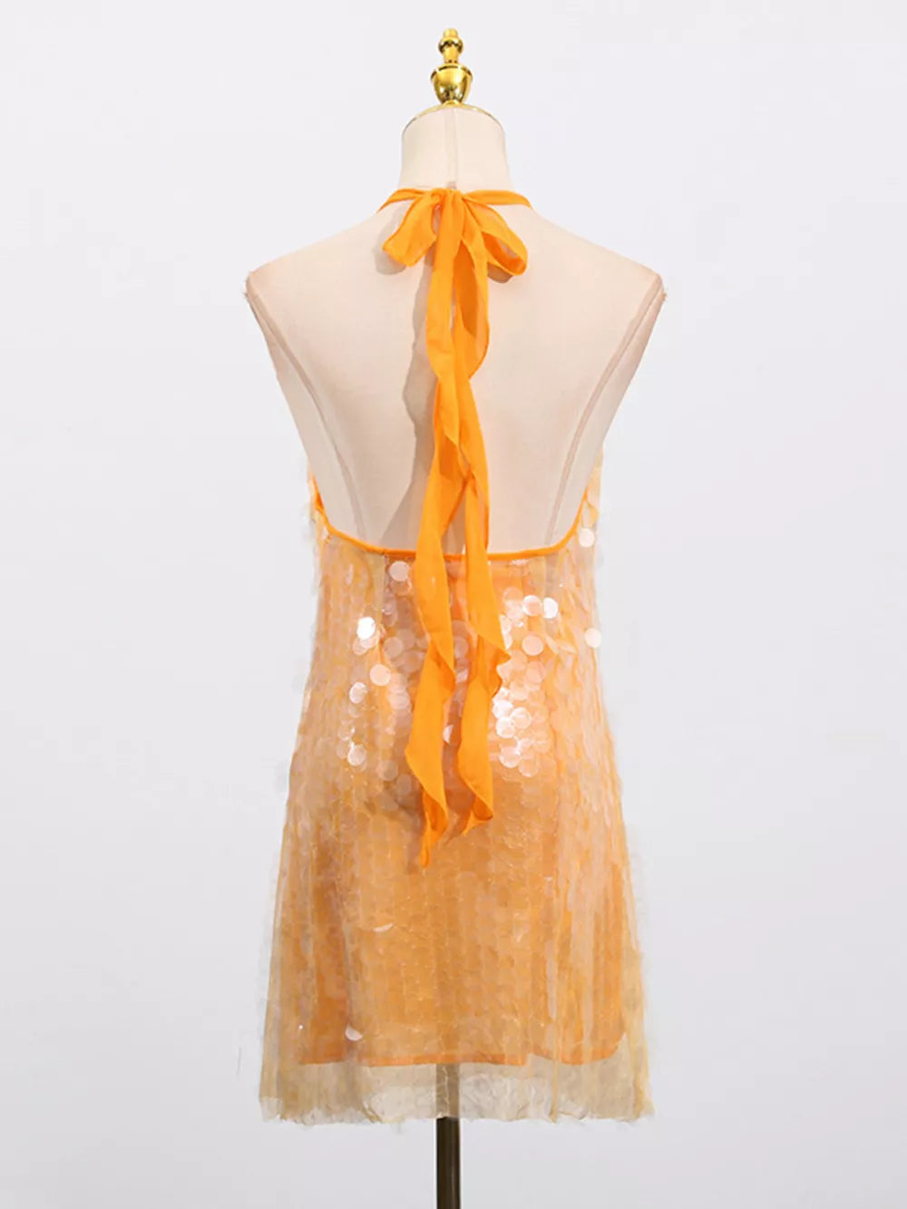 Orange iridescent sequin halter mini dress with tie back detail.