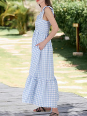 Blue gingham midi dress with smocked bodice, ruffled straps, pockets, and tiered hem.