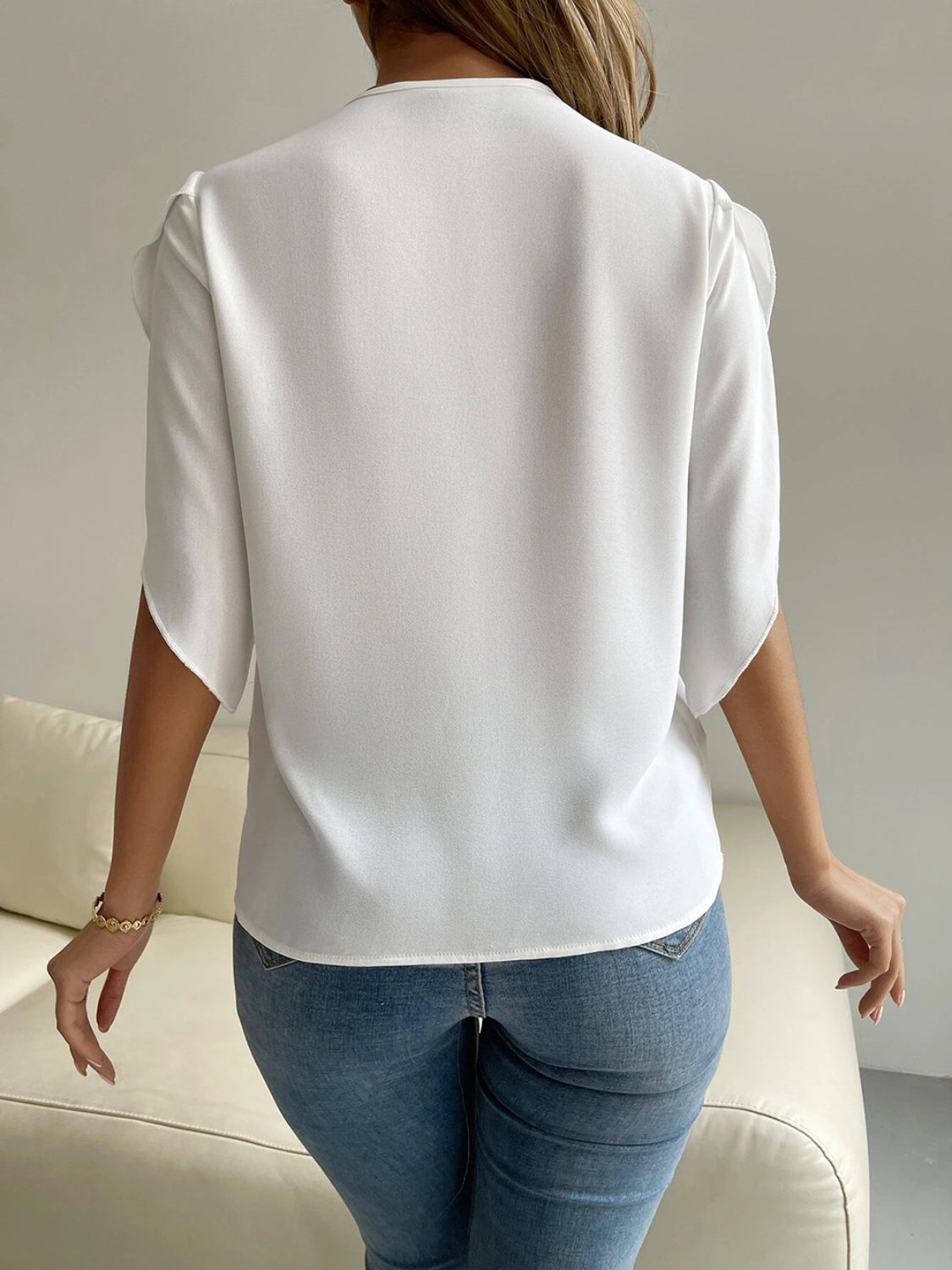 White polyester blouse with cape sleeves and lace trim detail.