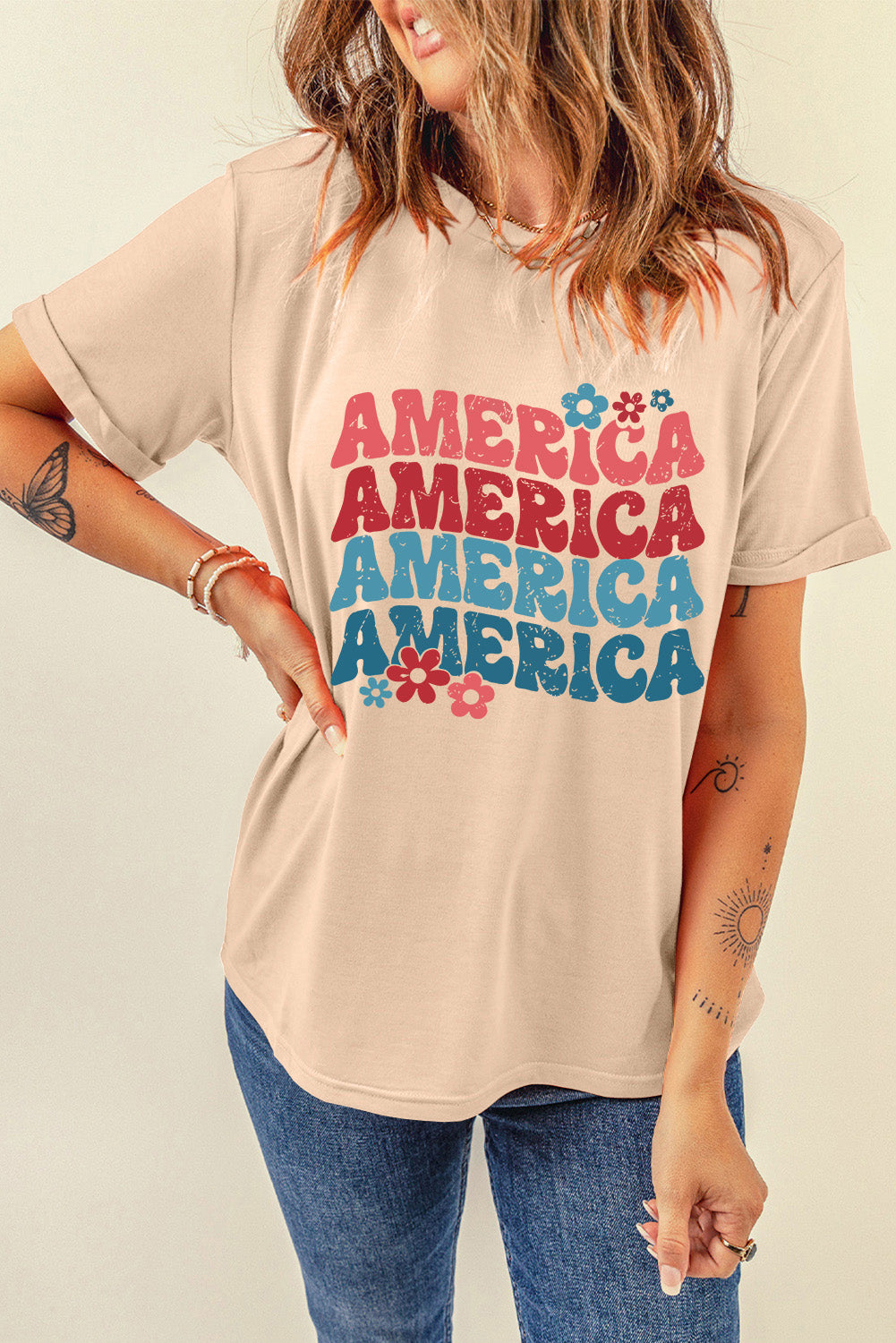 Tan graphic tee with stacked "America" text and floral accents.