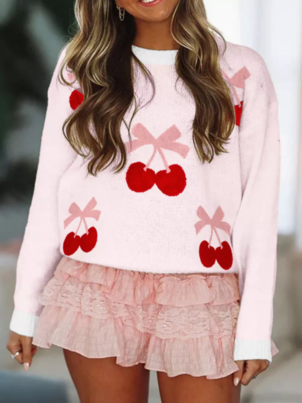 Pink knit sweater with red cherry and pink bow appliqués, crew neck, long sleeves.